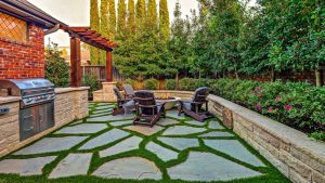 a patio with chairs, grill and a fire pit